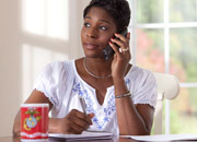 Woman talking on the phone and writing in a notebook